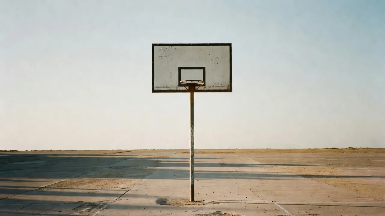Outdoor basketball hoop and backboard against a bright sky